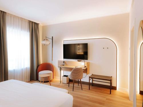 a hotel room with a bed and a desk at Mövenpick Hotel Bari in Bari
