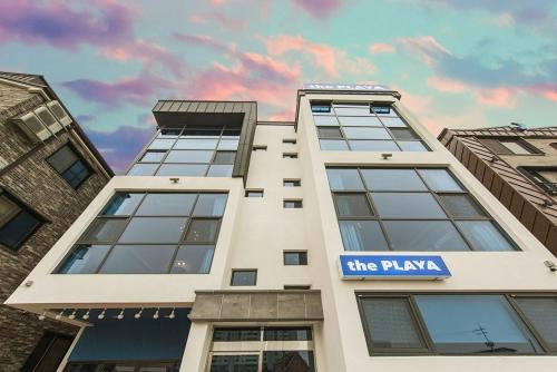 a white building with a blue sign on it at Daecheon Boryeong the Playa Pension in Boryeong