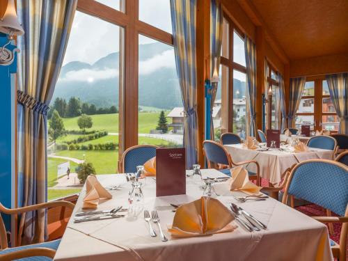 a restaurant with tables and chairs and a large window at Vivea Gesundheitshotel Bad Häring in Bad Häring