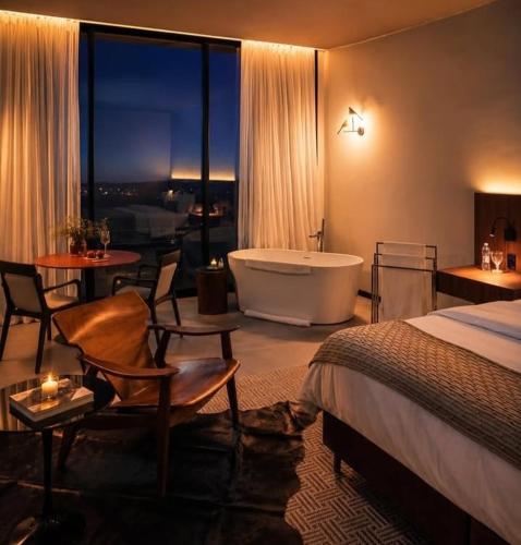 a hotel room with a bed and a bath tub at Vinicola Spirito in Espirito Santo Do Pinhal