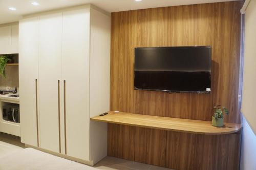 a living room with a flat screen tv on a wall at Studio moderno no coração da Cidade Baixa in Porto Alegre
