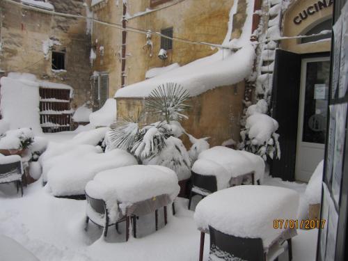 a group of chairs covered in snow next to a building at Sax Barisano in Matera