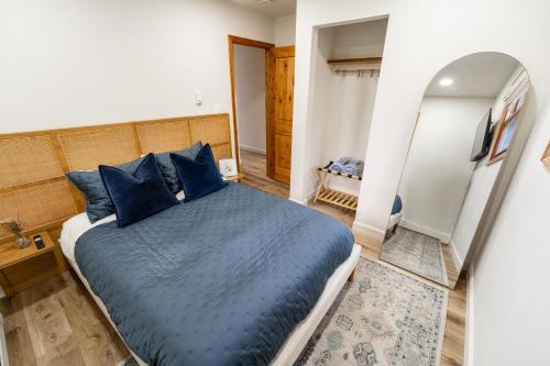 a bedroom with a blue bed and a mirror at Modern Designed Cabin with Secluded Backyard Firepit Grill Nintendo Switch2 in Gouldsboro