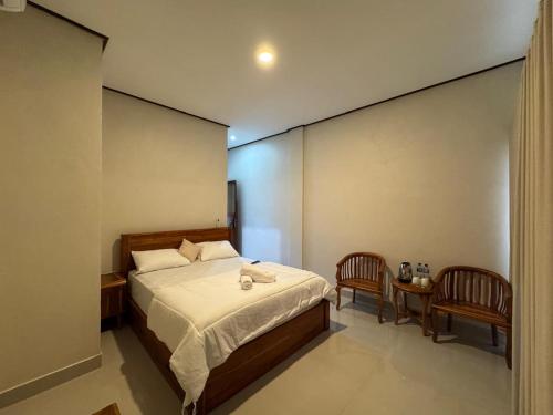 a bedroom with a bed and a table and chairs at Swariguna homestay in Sidemen