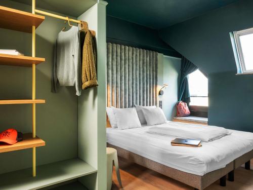 a bedroom with a bed and a blue wall at ibis Styles Hasselt City Centre in Hasselt