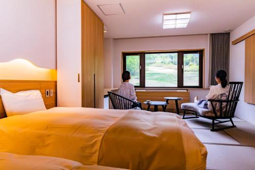two women sitting in chairs in a hotel room at Kyukamura Myoko in Myoko