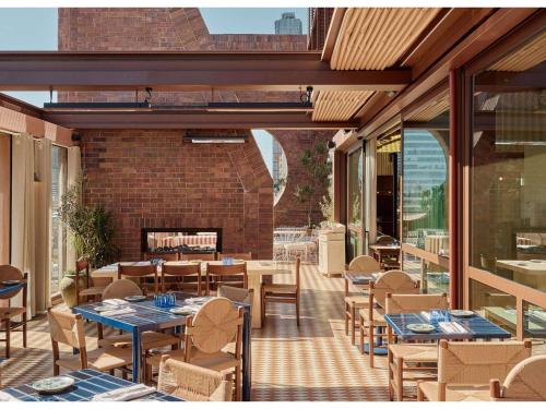 a patio with tables and chairs and a fireplace at Hyde Melbourne Place in Melbourne