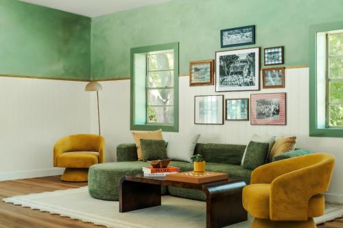 a living room with a green couch and two chairs at Petit Cowboy in New Braunfels