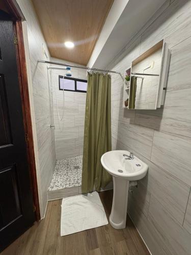a small bathroom with a sink and a shower at Hostal Sunset Town in Ahuachapán