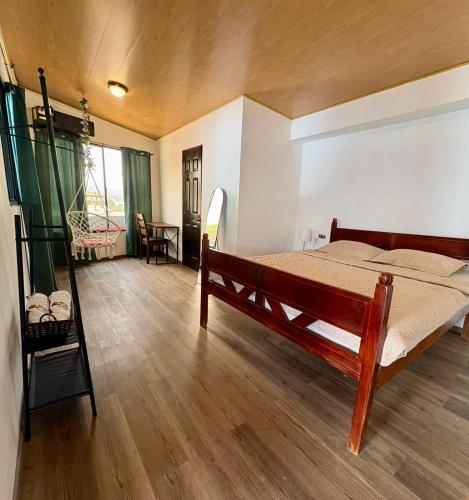 a bedroom with a bed and a wooden floor at Hostal Sunset Town in Ahuachapán