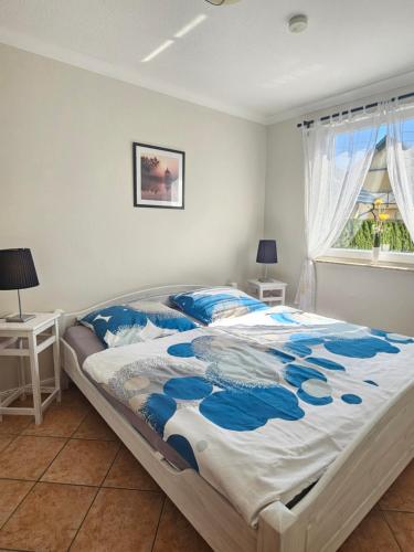 a bedroom with a large bed with blue and white sheets at Ferienwohnung Hugo in Zempin