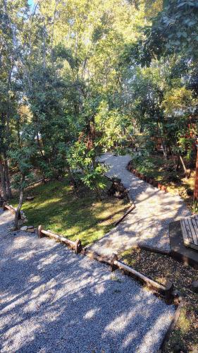 a park with a bench and a path with trees at Cabañas Tía Marce, Los Lleuques in Recinto