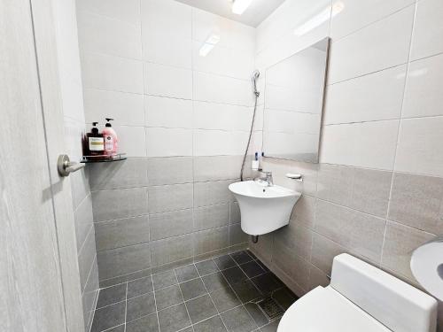a white bathroom with a sink and a toilet at Haemorat Pension in Seogwipo