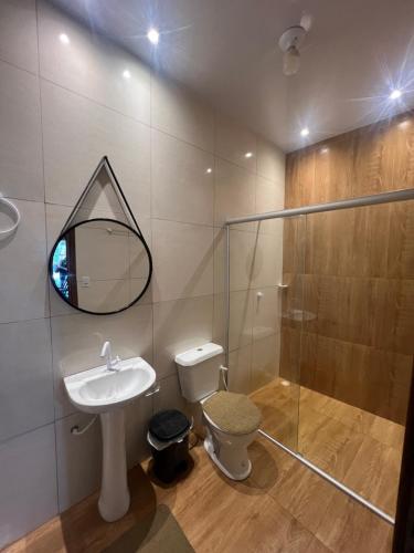 a bathroom with a toilet and a sink and a shower at Recanto Paraiso Tropical- Praia Ajuruteua in Bragança