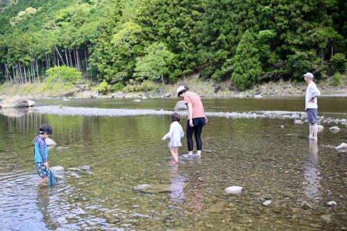 a group of people standing in a river at SEN RETREAT TAKIJIRI - Kumano Kodo Gateway in Tanabe