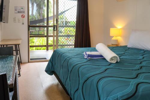 a bedroom with a bed with a blue blanket and a window at Wongai Beach Hotel in Horn