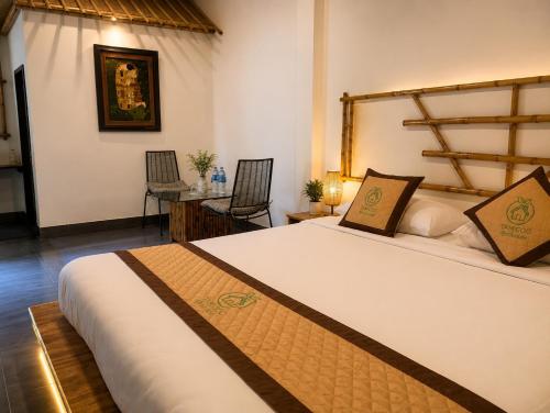 a bedroom with a bed and a table with chairs at Tam Coc Eco House in Ninh Binh