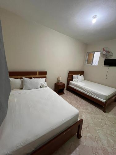 a bedroom with two beds and a window at Darlouis hotel bar piscine in Cap Haïtien
