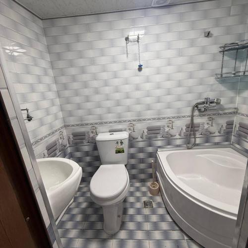 a bathroom with a toilet and a tub and a sink at Geniuses in Samarkand