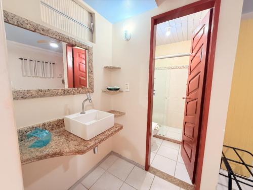 a bathroom with a sink and a mirror at Pousada Recifes de Corais in Porto De Galinhas