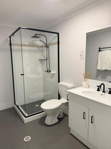 a bathroom with a shower and a toilet and a sink at Sussex View - Waterfront Couples Retreat in Sussex Inlet in Sussex Inlet
