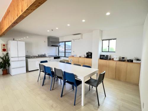 a kitchen and dining room with a white table and chairs at HOJO Brewing & Stays in Hōjō