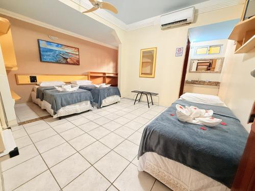 two beds in a room with two swans on them at Pousada Recifes de Corais in Porto De Galinhas