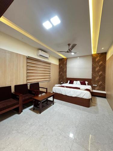 a bedroom with a bed and a table and chairs at S Hotel Neela in Musiri
