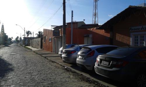 a row of cars parked on the side of a street at Pousada Jesmar in Praia do Frances