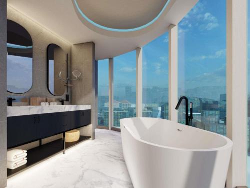 a bathroom with a large tub and large windows at Novotel Jakarta Pulo Mas in Jakarta