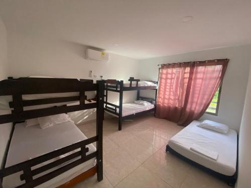 a room with three bunk beds and a window at Dream Country Cabin in Cañaveral