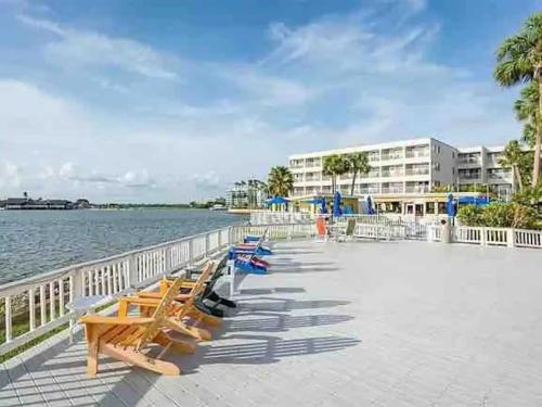 a row of wooden benches sitting next to the water at Bayfront 2BR2BA Condo at Sailport Minutes from Beaches & Downtown Attractions in Tampa