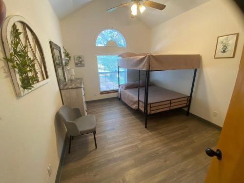 a small room with a bunk bed and a chair at Delaware Springs Home in Burnet