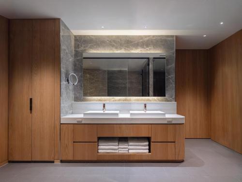 a bathroom with two sinks and a mirror at Lomä Central Peaks in Shinano