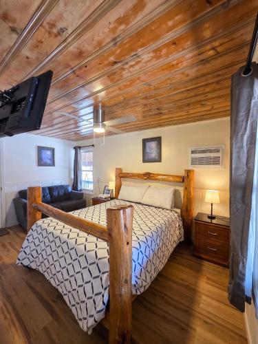 a bedroom with a bed with a wooden ceiling at Dawson House Lodge in Chemult