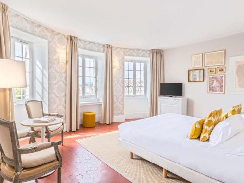 a bedroom with a bed and a table and chairs at Château de Mazan - Handwritten Collection in Mazan