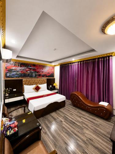a hotel room with two beds and a couch at Hoàng Gia Long Biên Hotel in Hanoi