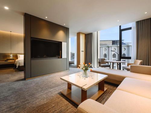 a living room with a couch and a tv at MOVENPICK TASHKENT OLD CITY in Tashkent