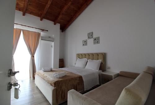 a bedroom with a bed and a couch at Hotel Beach Restaurant Fabio in Borsh