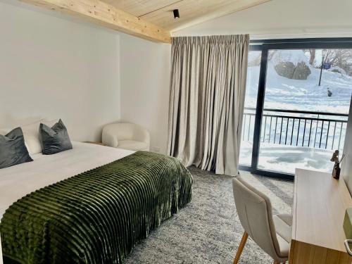 a bedroom with a bed and a large window at Carruthers Chalet in Perisher Valley