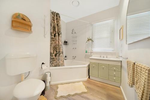 a bathroom with a tub and a toilet and a sink at The Ironbark Nest in Bendigo