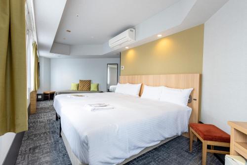 a bedroom with a large white bed in a room at E Hotel Higashi Shinjuku in Tokyo