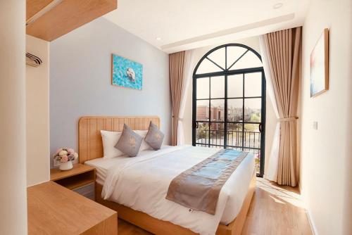 a bedroom with a large bed and a window at KB Villas 51 in Bình Tú
