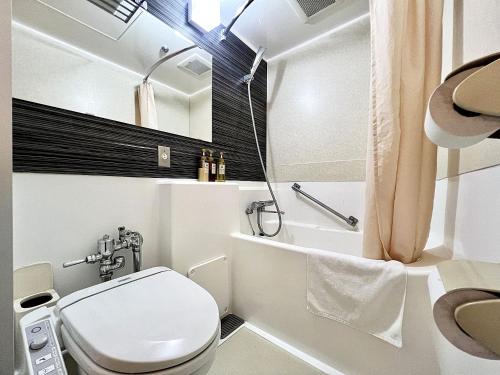 a white bathroom with a toilet and a shower at Hotel The Centre Utsunomiya in Utsunomiya