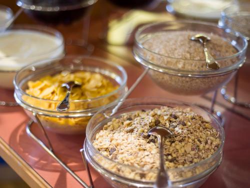 four bowls of food with spoons in them on a table at Vivea Gesundheitshotel Bad Häring in Bad Häring