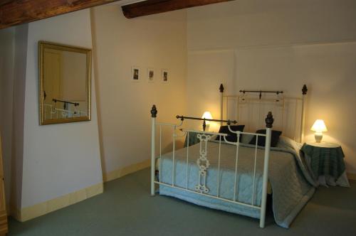 a bedroom with a bed and a mirror at L'Impasse du Temple in Léran
