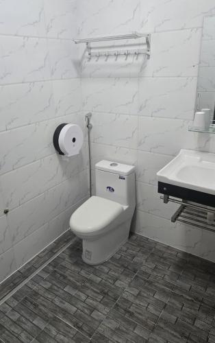 a white bathroom with a toilet and a sink at Ha Giang SkyPath Hostel & Tours in Làng Lap