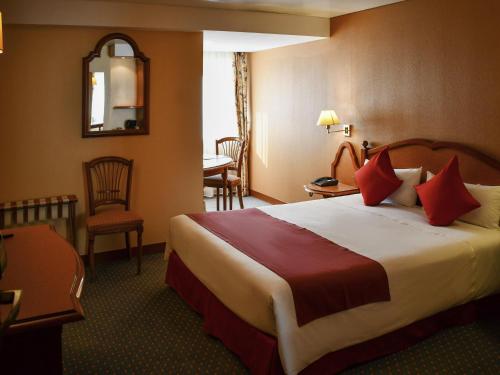 a hotel room with a large bed with red pillows at Mercure Andorra in Andorra la Vella