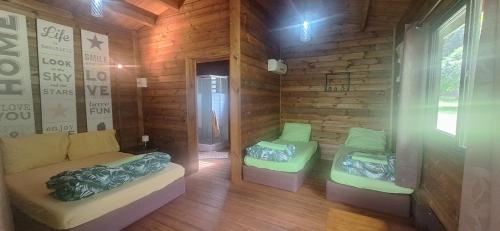 a room with two beds in a wooden cabin at Oasis 56 Aéroport Tontouta in La Tontouta