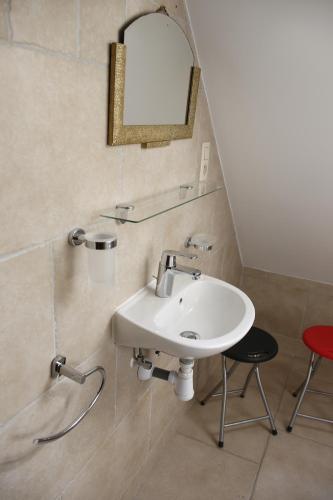 baño con lavabo, espejo y taburete en Au Grenier des Coccinelles, en Pecq